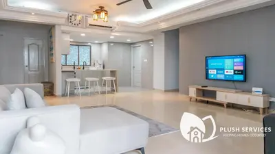 a living room with a couch and a tv on a wall at Angkasa Impian 1 @ Bukit Bintang in Kuala Lumpur