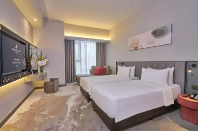 a hotel room with two beds and a flat screen tv at Sleeping Lion Suites in Kuala Lumpur