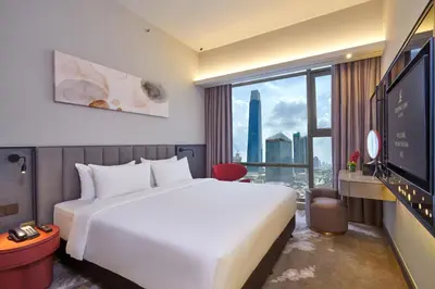 a hotel room with a large bed and a large window at Sleeping Lion Suites in Kuala Lumpur
