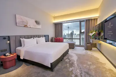 a hotel room with a large bed and a large window at Sleeping Lion Suites in Kuala Lumpur