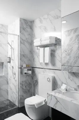 a white bathroom with a toilet and a sink at THE FACE Style Hotel in Kuala Lumpur