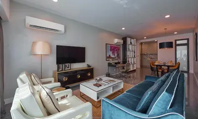 a living room with a blue couch and a tv at THE FACE Style Hotel in Kuala Lumpur