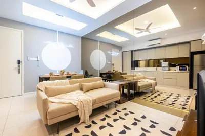 a living room with chairs and a table and a kitchen at Dorsett Residences Hartamas Kuala Lumpur by Feel Home in Kuala Lumpur