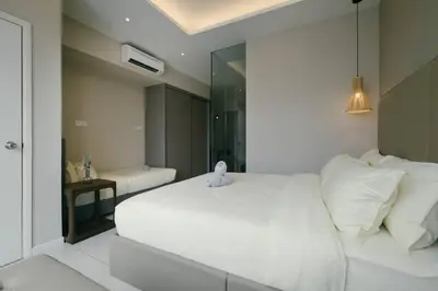 a bedroom with a white bed with a stuffed animal on it at Dorsett Residences Hartamas Kuala Lumpur by Feel Home in Kuala Lumpur