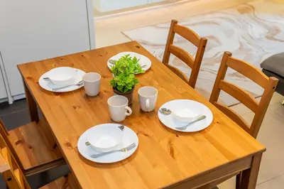 a wooden table with plates and a plant on it at Arcoris Mont Kiara in Kuala Lumpur