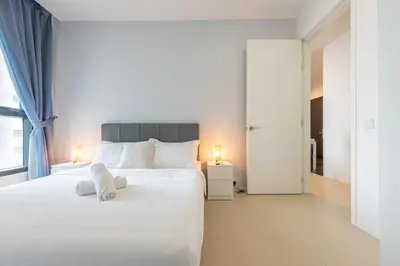 a bedroom with a large white bed and a window at Arcoris Mont Kiara in Kuala Lumpur