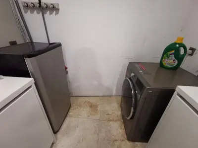 a small kitchen with a washing machine and a counter at Vortex Suites KLCC by C&C Fortune in Kuala Lumpur