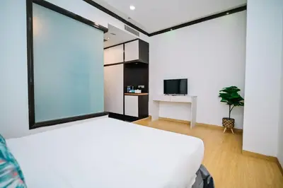 a bedroom with a white bed and a tv at Kingston Hotel 5 - Chow Kit in Kuala Lumpur