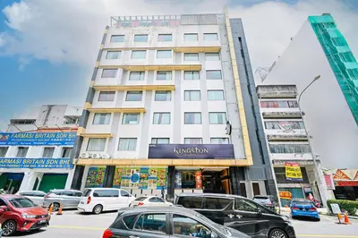 a tall building with cars parked in a parking lot at Kingston Hotel 5 - Chow Kit in Kuala Lumpur