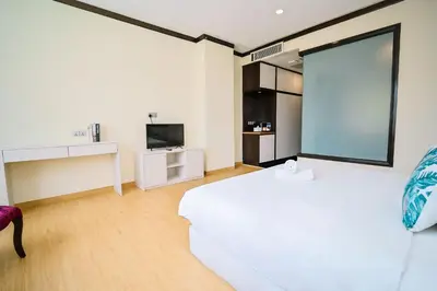 a white bedroom with a large bed and a tv at Kingston Hotel 5 - Chow Kit in Kuala Lumpur