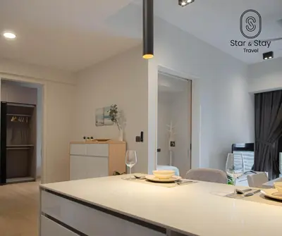 a kitchen and living room with a table and chairs at AXQUISITE SUITES at KLCC in Kuala Lumpur