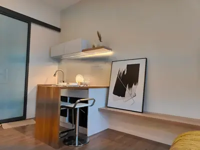 a kitchen with a bar with a sink and a stool at Ceylonz Suites in Kuala Lumpur