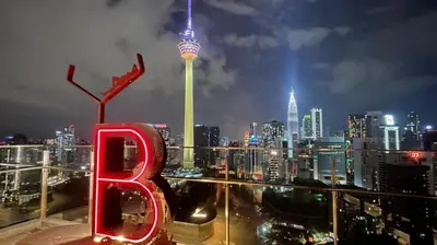 a view of a city at night with the space needle at Ceylonz Suites in Kuala Lumpur