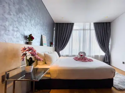 a bedroom with a bed and a glass table with flowers at The Luxury Penthouses KLCC Petronas Twin tower Kuala Lumpur in Kuala Lumpur