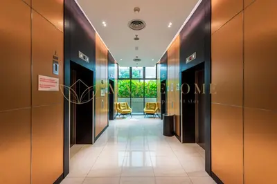 a corridor in a building with chairs in the hallway at The Colony and The Luxe Premier Suites Kuala Lumpur in Kuala Lumpur