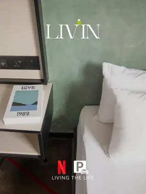 a bed with a clock on a night stand next to it at #16 M101 Dang Wangi KLCC View Pool By Livin in Kuala Lumpur