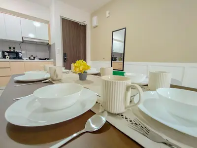 a dining room table with white plates and spoons at M Vertica By Minsu in Kuala Lumpur