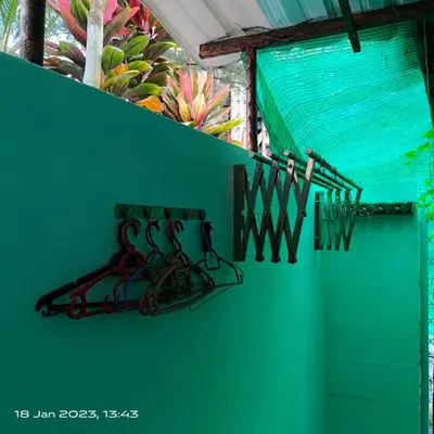 a green wall with a rack on the wall at Cheras Homestay Family room with Private Bathroom in Kuala Lumpur