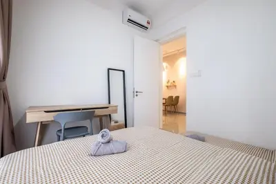 a bedroom with a bed and a desk with a towel at Muji Home 2BR 4Pax Southlink Nexus Bangsar South in Kuala Lumpur