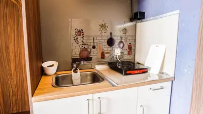 a small kitchen with a sink and a stove at Bangsar Trade Centre by Airhost in Kuala Lumpur