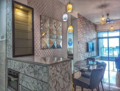 a kitchen with a counter with a glass table and chairs at Legasi 3-bedroom condo - 5 mins walk to KLCC in Kuala Lumpur