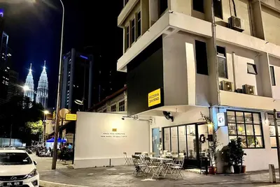 a building with tables and chairs on a city street at night at #211 M101 Dang Wangi KLCC View Pool By Livin in Kuala Lumpur