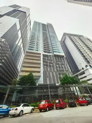 a tall building with cars parked in a parking lot at Summer Suites by Moon Orchid in Kuala Lumpur