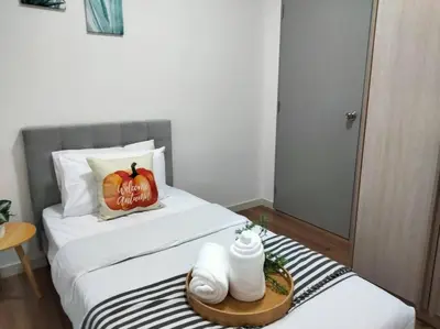 a bedroom with a bed with a pumpkin pillow and towels at M Vertica Residence I HomeBrickz in Kuala Lumpur