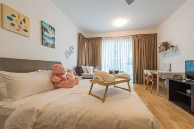a teddy bear sitting on a bed in a living room at MITEC Publika 500Mbp Wi-fi Studio Mont Kiara Hartamas in Kuala Lumpur
