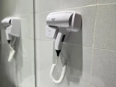 a white hair dryer hanging on a wall at Smile Hotel Cheras Sri Permaisuri in Kuala Lumpur