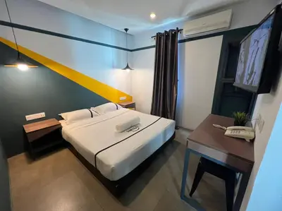a bedroom with a bed and a desk with a phone at Smile Hotel Cheras Sri Permaisuri in Kuala Lumpur