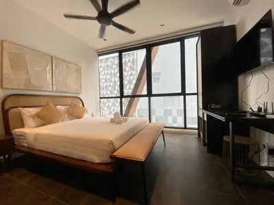 a bedroom with a large bed with a ceiling fan at Infini Suites@ Scarletz Suites KLCC in Kuala Lumpur