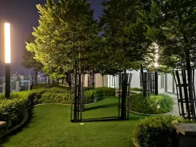 a garden with trees and grass at night at Orion Suites@ The Robertson Bukit Bintang in Kuala Lumpur
