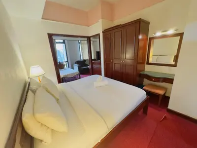 a bedroom with a bed with white sheets and a mirror at Times Square East privite service Apartment in Kuala Lumpur