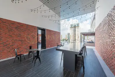 a room with tables and chairs and a brick wall at Chambers Premier Suites Kuala Lumpur in Kuala Lumpur
