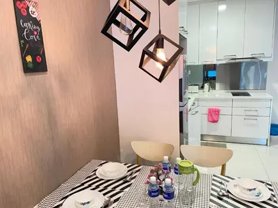 a dining room with a table and a kitchen at Mercu Summer Suite KLCC by Minshuku in Kuala Lumpur