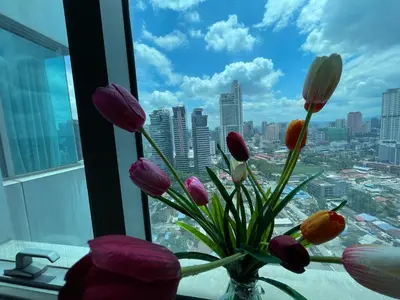 a vase filled with flowers in a window at Mercu Summer Suite KLCC by Minshuku in Kuala Lumpur