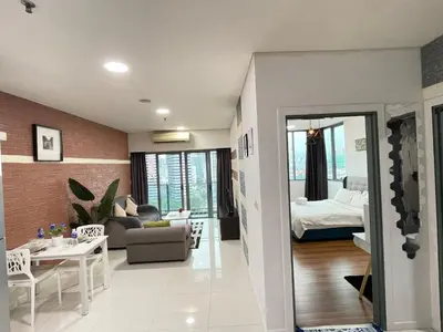 a living room with a couch and a bed and a table at Mercu Summer Suite KLCC by Minshuku in Kuala Lumpur