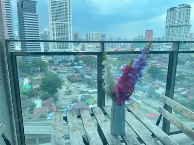 a vase of flowers sitting on a table in a window at Mercu Summer Suite KLCC by Minshuku in Kuala Lumpur