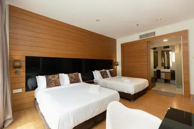 two beds in a hotel room with wooden walls at Dua Sentral Residence near KL Sentral by COBNB in Kuala Lumpur