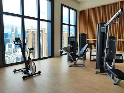 a gym with bikes and exercise equipment in a room with windows at Premium Suites by Home Horizon at Lucentia Residence in Kuala Lumpur