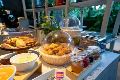 a buffet with bread and pastries in glass domes at Ceylonz KLCC by Mana-Mana in Kuala Lumpur