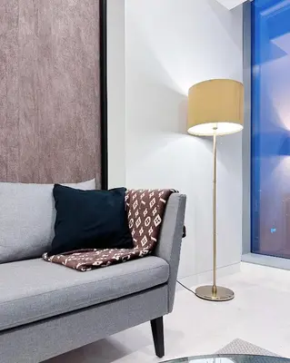 a living room with a couch and a lamp at Tropicana The Residence LV Suite with KLCC View in Kuala Lumpur