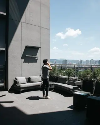 a man standing on top of a building talking on a cell phone at EXPRESSIONZ KLCC BY MANA-MANA in Kuala Lumpur