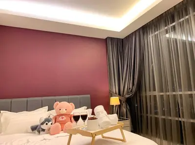 a bed with two teddy bears and two glasses of wine at MITEC Publika 2Br Hot tub Sri Hartamas Mont Kiara in Kuala Lumpur