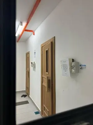 a hallway with two doors and a sign on a wall at KLCC Kampung Baru Cottage - Homestay in Kuala Lumpur