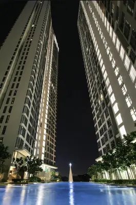 two tall buildings at night with a fountain in between them at S37- Bukit Bintang 3 Bedroom Suite with Netflix Robertson in Kuala Lumpur