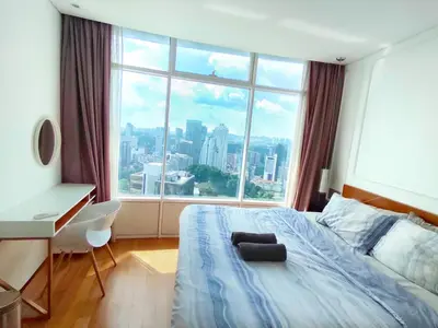 a bedroom with a bed and a desk and a large window at Luxury 2BR Home in Vortex Stunning KL Tower View Free WiFi in Kuala Lumpur
