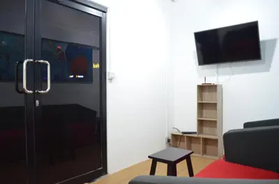 a living room with a black door and a tv at RED ROOM Kuala Lumpur in Kuala Lumpur