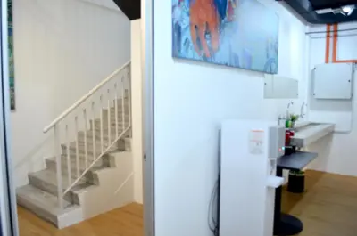 a staircase in a living room with a painting on the wall at RED ROOM Kuala Lumpur in Kuala Lumpur